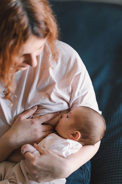 Newborn baby girl sucking milk from mothers breast Portrait of mom and breastfeeding baby Concept of healthy and natural baby breastfeeding nutrition