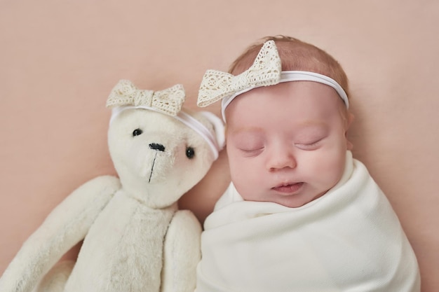 Newborn baby girl with toy bear Healthy child Happy motherhood and parenting