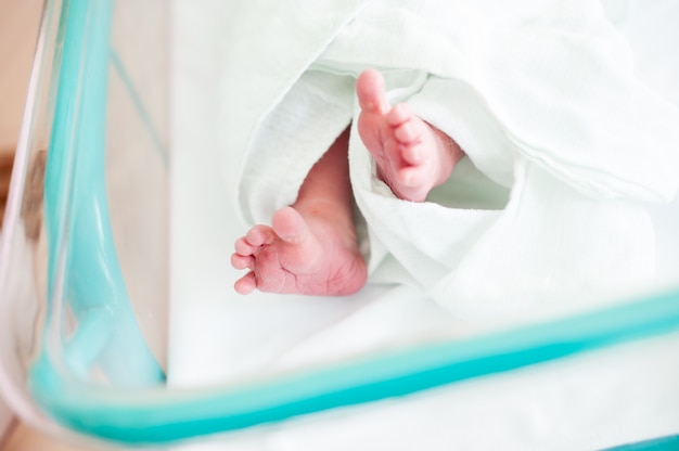 Новорожденный ребенок в больнице с липкой лентой на руке