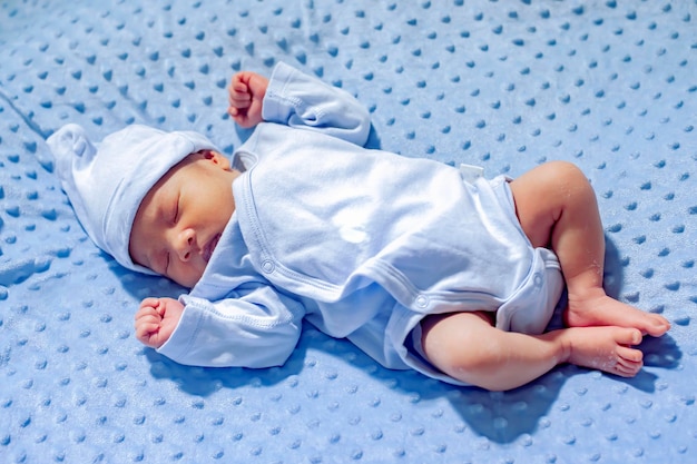 A newborn baby is sleeping happily. in his bed