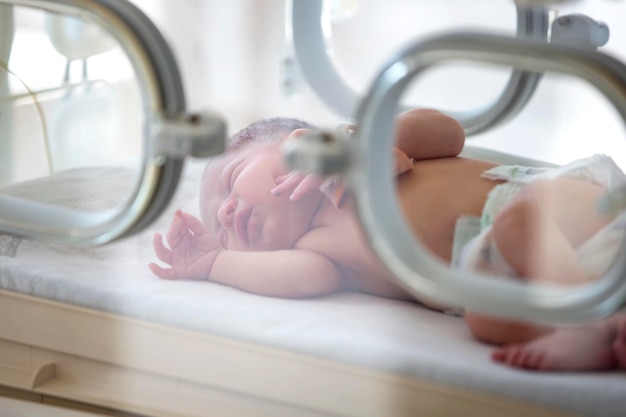 A newborn baby lies in boxes in the hospital