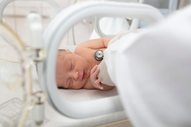 Un neonato giace in scatole in ospedale