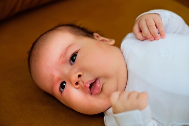 Newborn baby lies on the dewan newborn baby shows different emotions