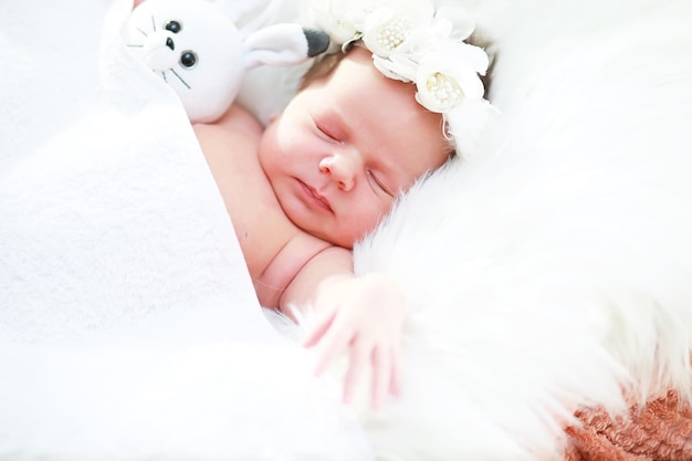 A newborn baby lies in her mother's arms A beautiful baby of European appearance is sleeping