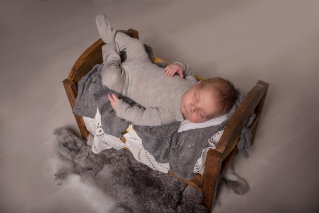 Новорожденный ребенок лежит, спит, зевает в концепции рождения мальчика в кроватке