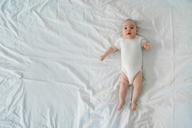 Newborn baby lies on a white background.