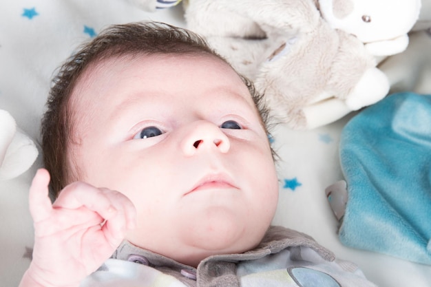 A newborn baby lying in bed at home