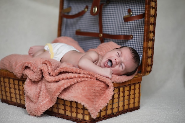 毛布の上に横たわって寝ている新生児