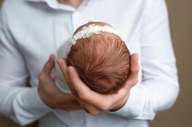 Photo newborn baby lying with his head on the hand of the father