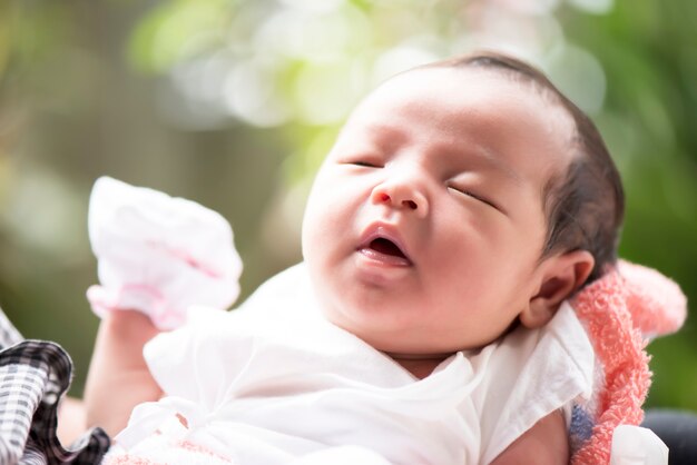 Newborn baby open her mouth in mother's hands, selective focus in her eyes, Family concept