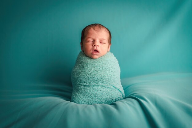 A newborn baby sleeping in a ball of wool