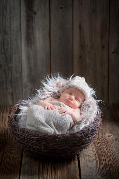 毛布の上のバスケットで眠っている生まれたばかりの赤ちゃん