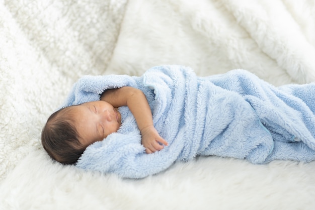 Newborn baby sleeping in bed