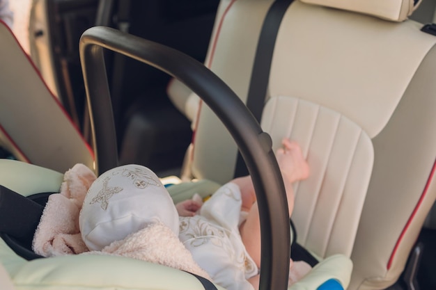 車の座席で寝ている生まれたばかりの赤ちゃん