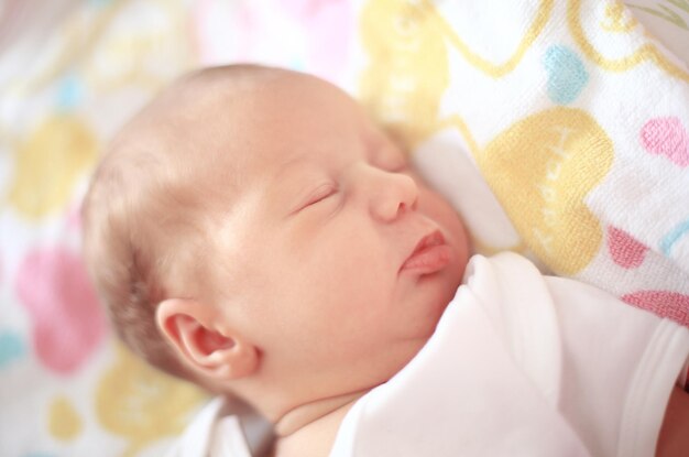 Newborn baby sleeping in the crib on a blanket