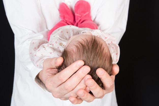 Neonato che dorme sulle mani di suo padre