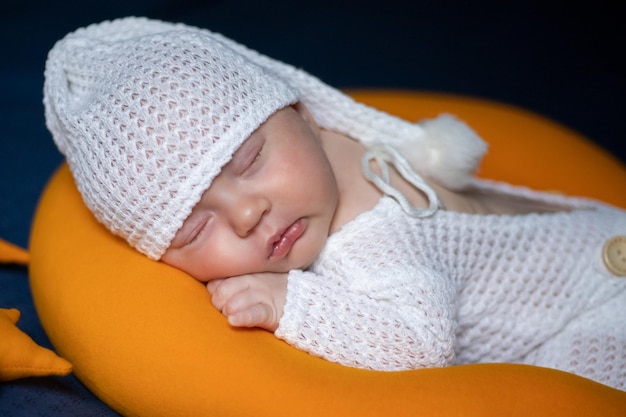 Newborn baby sleeps in a sleep cap closeup