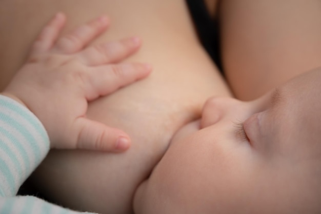 Newborn baby sucks mother's breast milk Beautiful tranquil child peacefully sleeping