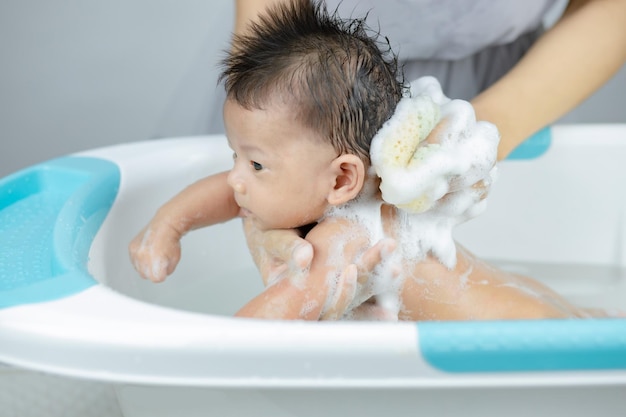 Newborn baby taking bath in a shower