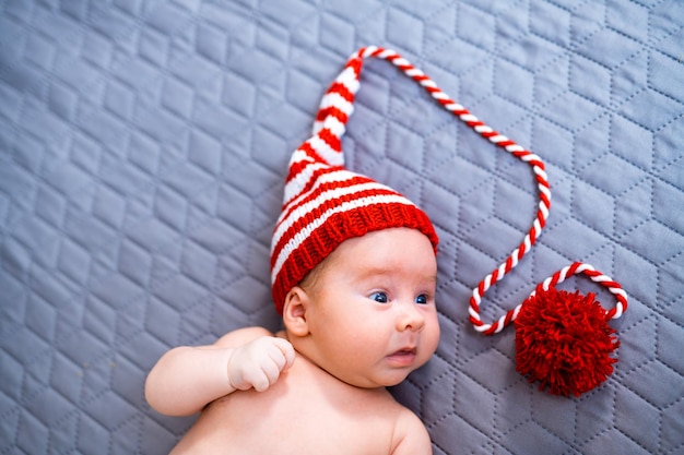 Newborn baby wearing a knitted Christmas elf hat