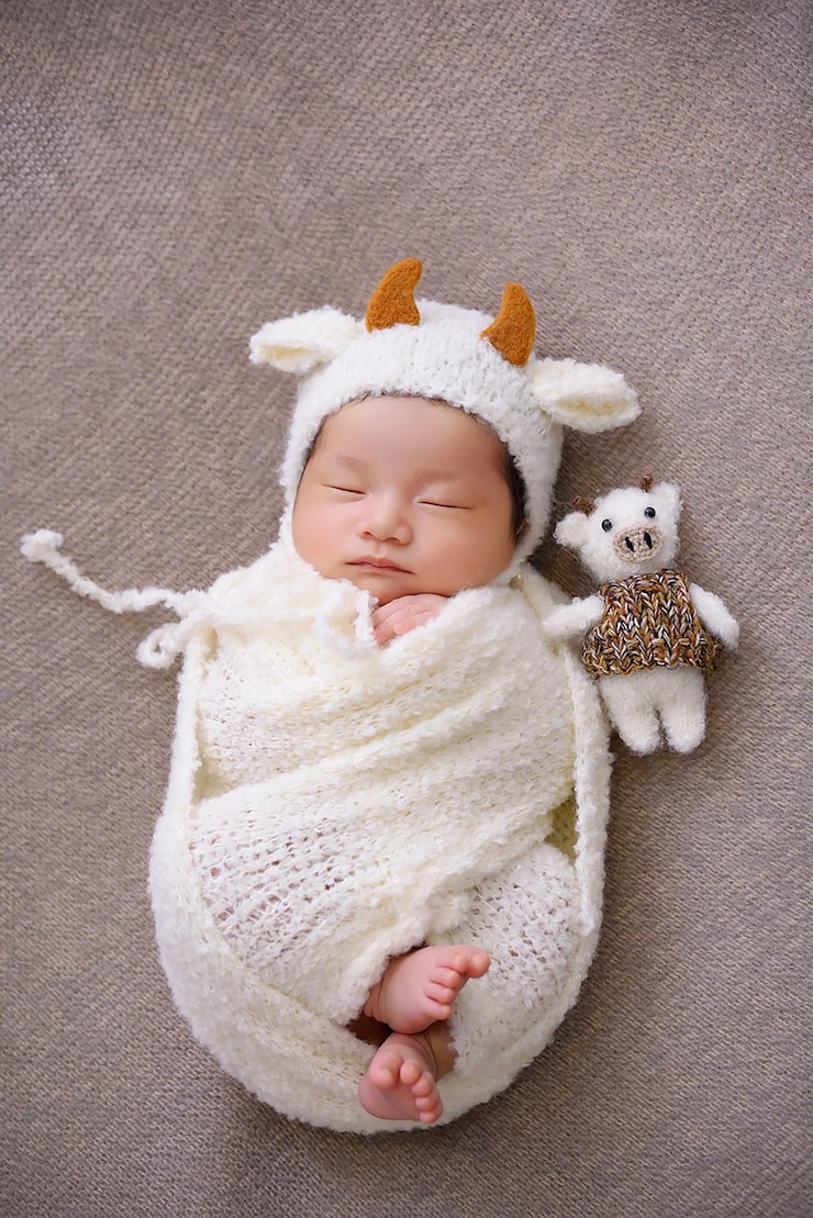 Photo 角とぬいぐるみの白い帽子をかぶった新生児