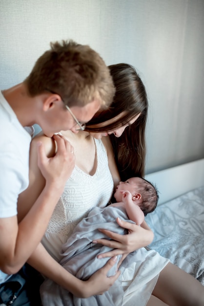 Новорожденный ребенок с мамой и папой дома
