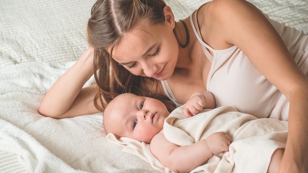 Newborn baby with mother on the bed