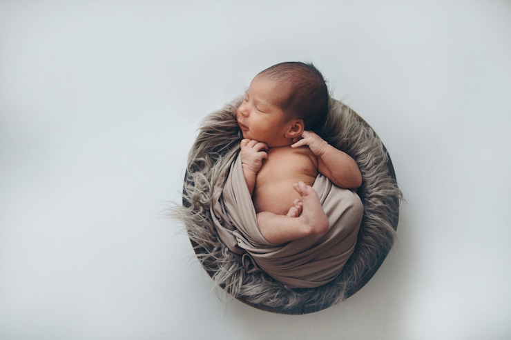Photo newborn baby wrapped in a blanket sleeping in a basket. concept of childhood, healthcare, ivf.