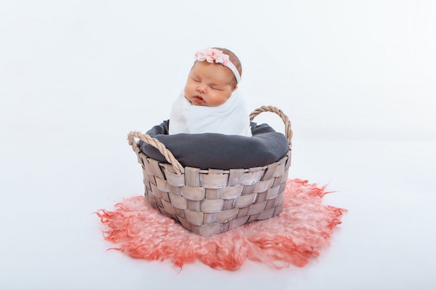 Newborn baby wrapped in a blanket sleeping in a basket. concept of childhood, healthcare, IVF.