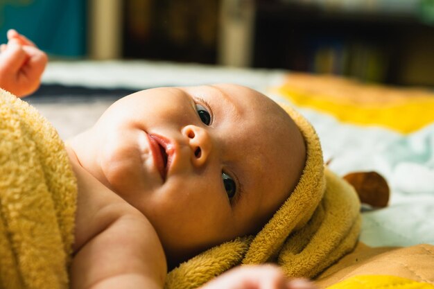 A newborn baby wrapped in a towel after bathing The concept of childhood and infant care