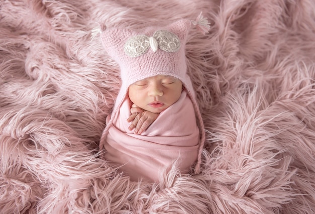 Newborn in beanie hat on a shaggy carpet