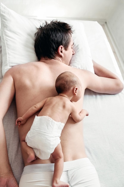 A newborn boy lies on his father's back