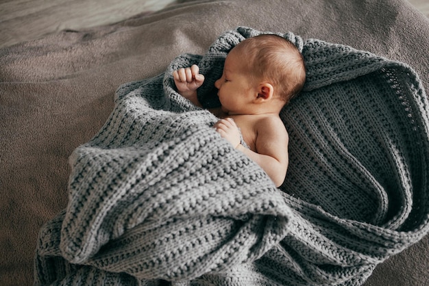 Newborn boy lies on a plaid