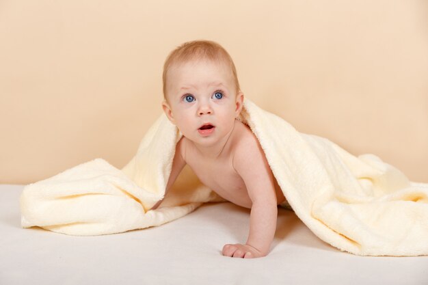 Newborn child on the bed under a blanket