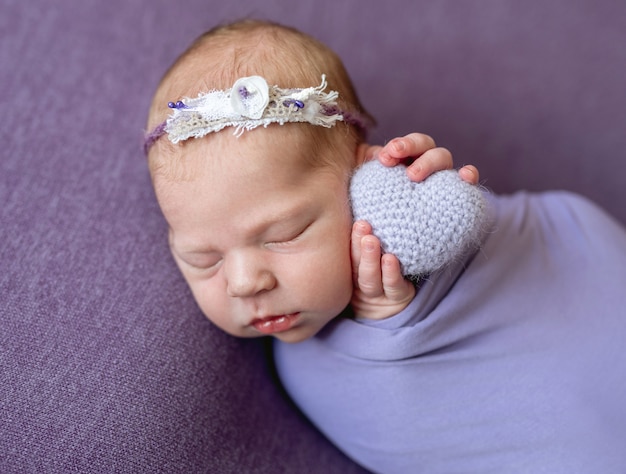 Newborn child with knitted heart