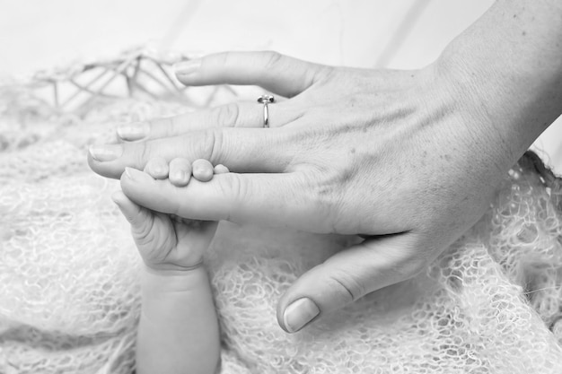 Newborn children's hand in mother hand Mom and her Child Happy Family concept