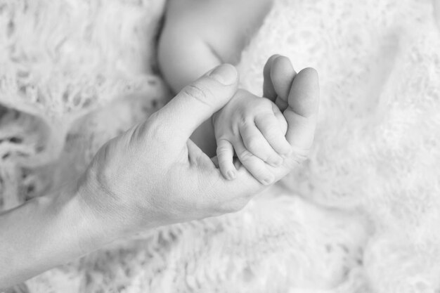 Photo newborn children's hand in mother hand mom and her child happy family concept