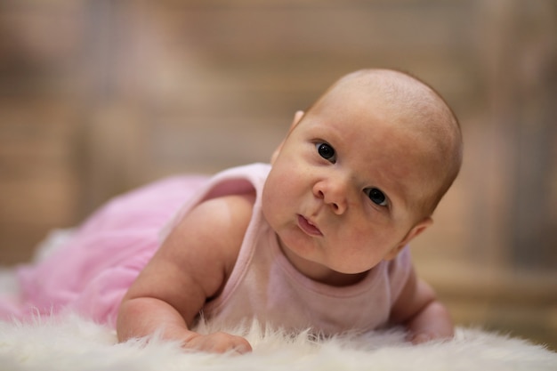 Newborn cute baby lying on a white fur skin