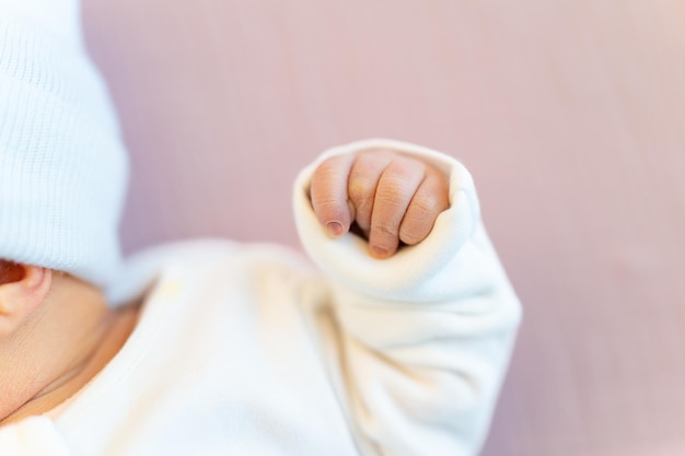 Newborn girl first days after birth in postpartum department Baby's tiny hand