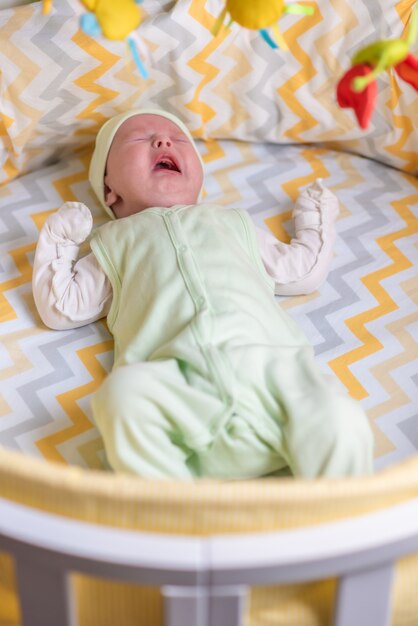 a newborn is crying in the crib because of colic