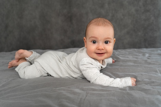 A newborn lies on his stomach and smiles. 