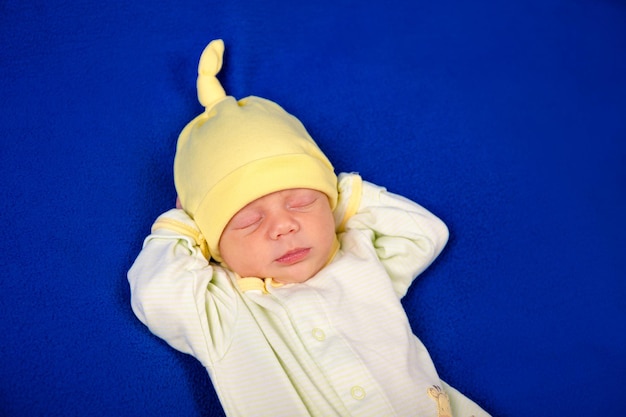 Photo newborn little boy sleeping on a blue blanket baby goods packaging