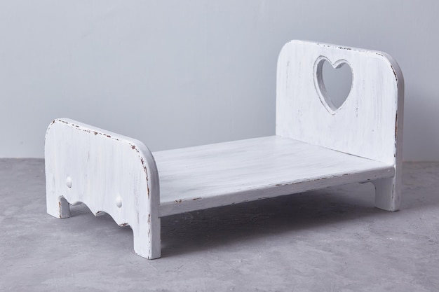 Newborn props for the photographer. background. white wooden\
baby bed on a gray background.