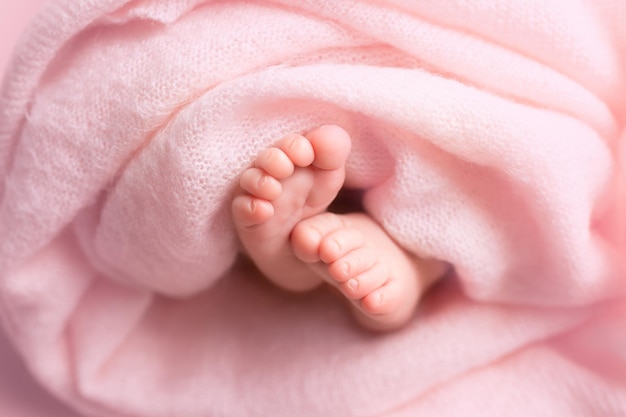 Фото Ножки новорожденного в розовой ткани вокруг цветов уход за ножками маленького ребенка и комфорт семейная гигиена