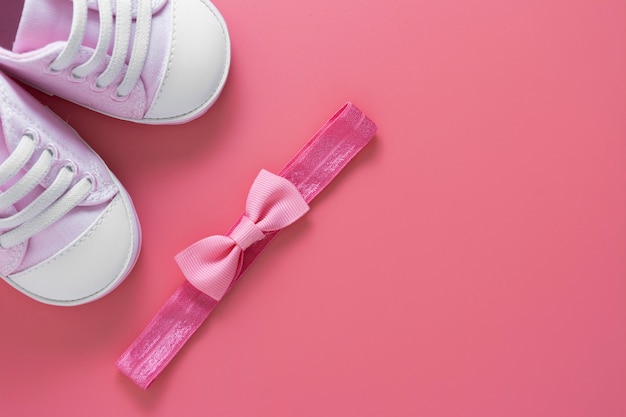 Newborn shoes and head band with bow. Creative baby girl flat lay. Copy space.