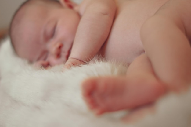 Photo newborn shooting in aesthetic studio cute little baby sleeping pacefuly in a fur out of basket in a beige background