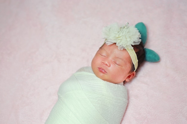 Newborn sleeping on a fluffy soft bed