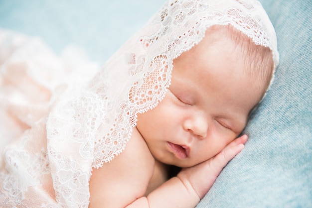 Neonato che dorme con la mano sotto la guancia