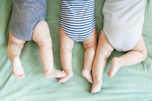 Photo newborn triplets lie on a stomach on a blanket