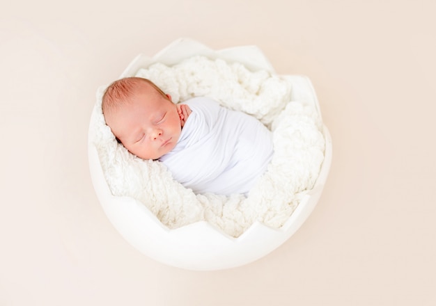 Фото Новорожденный спит в колыбели в форме яйца